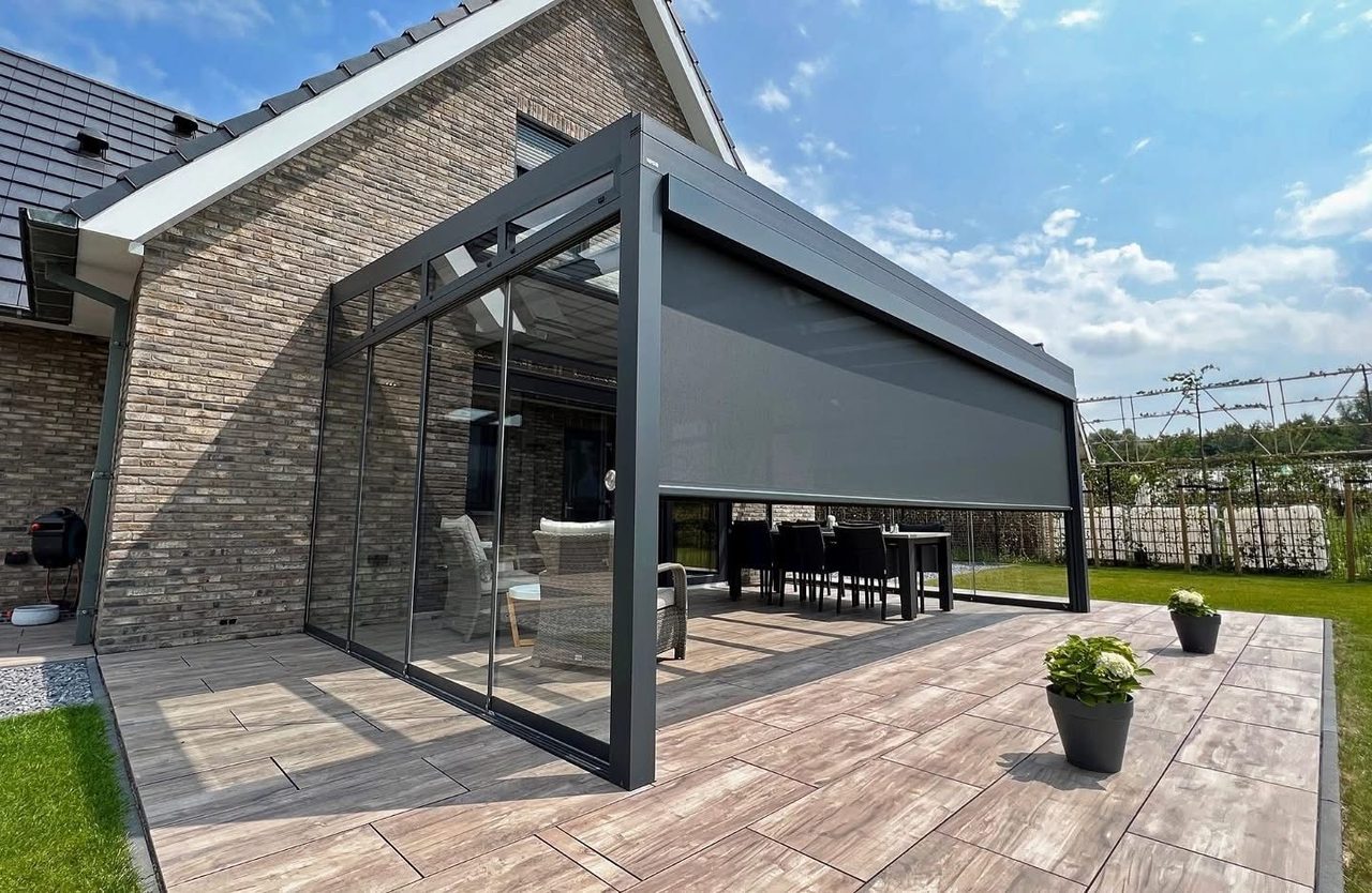 Veranda mit Senkrechtmarkise und Glasschiebewänden auf einer Terrasse mit Holzoptikplatten